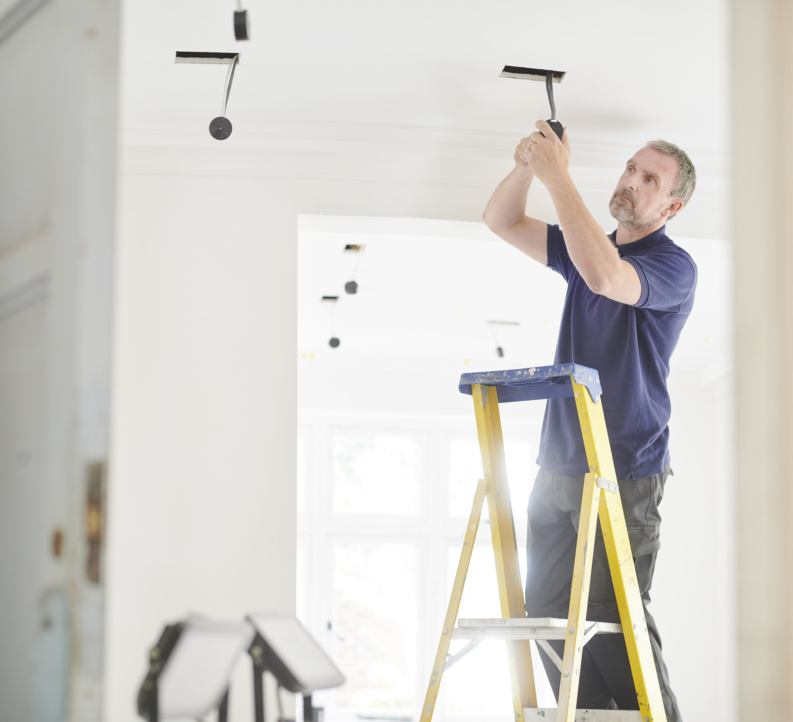 Electrician installing downlights